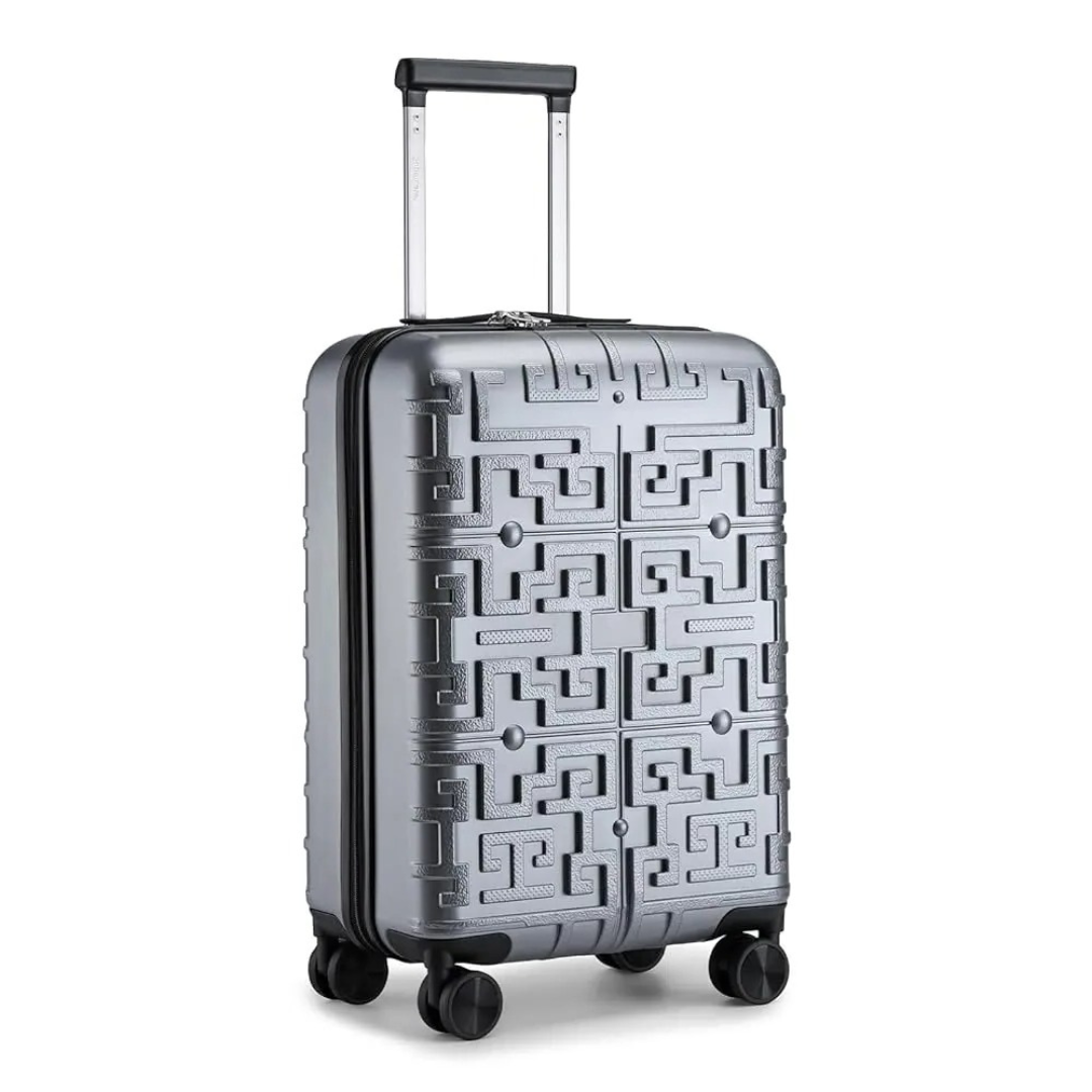 Valise rigide argentée avec motif géométrique en relief, dotée d’une poignée télescopique et de 4 roues pivotantes 360° pour une maniabilité optimale.