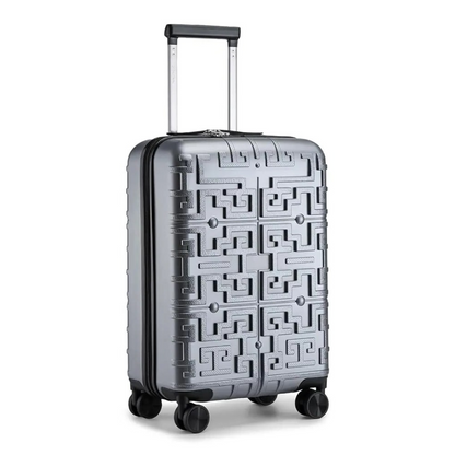 Valise rigide argentée avec motif géométrique en relief, dotée d’une poignée télescopique et de 4 roues pivotantes 360° pour une maniabilité optimale.