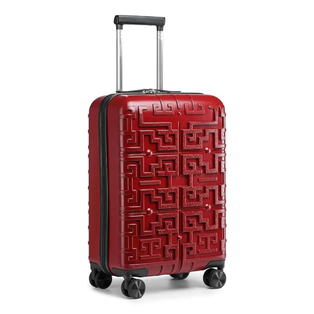 Valise rigide rouge avec motif géométrique en relief, équipée d’une poignée télescopique et de 4 roues pivotantes 360° pour un déplacement facile.